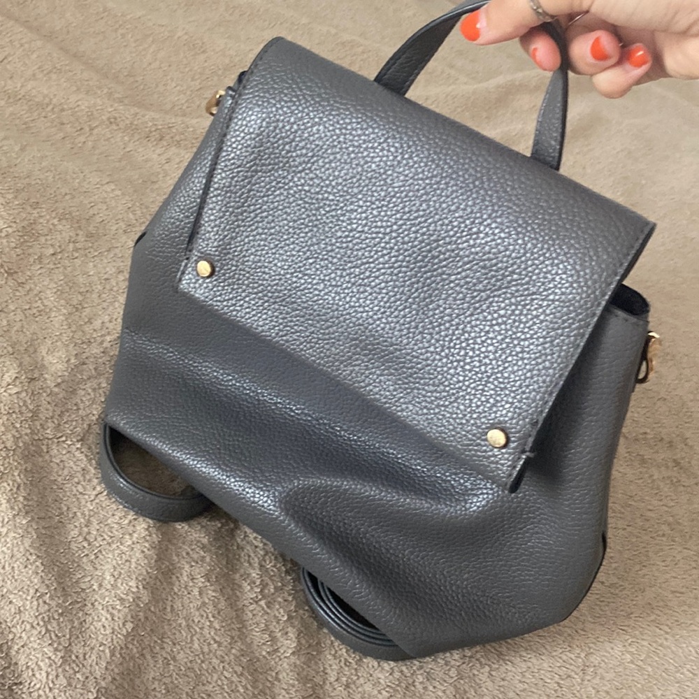gray leather back pack with gold accents.